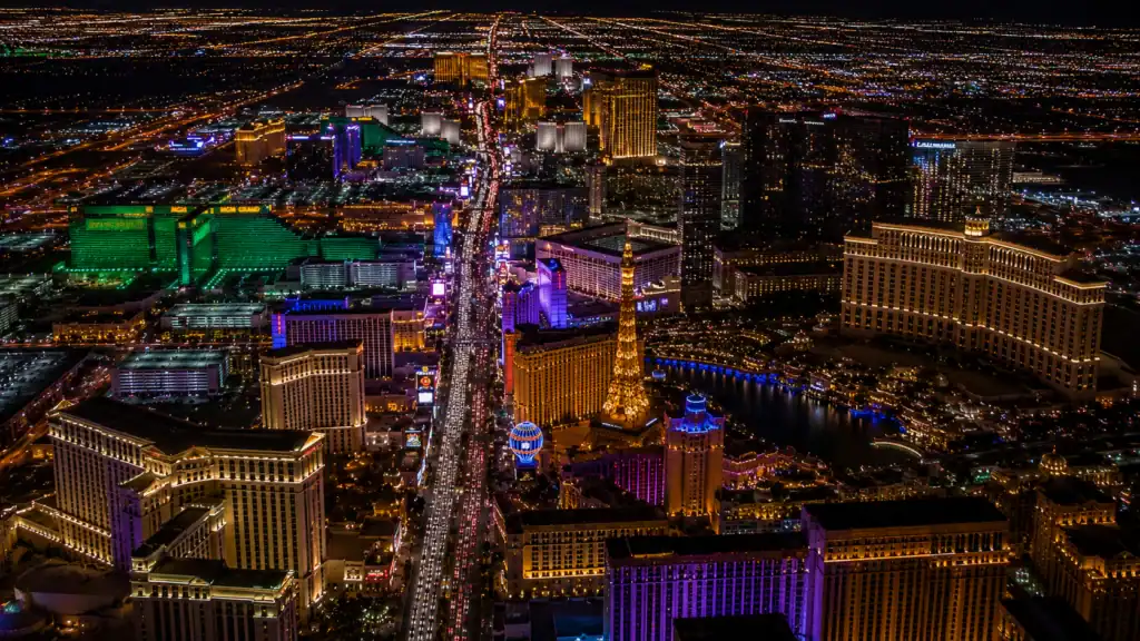Aerial nighttime view of Las Vegas Strip resort hotel towers all illuminated showing MGM Grand Bellagio Caesars Palace Wynn and Venetian representing Las Vegas hotel inventory statistics