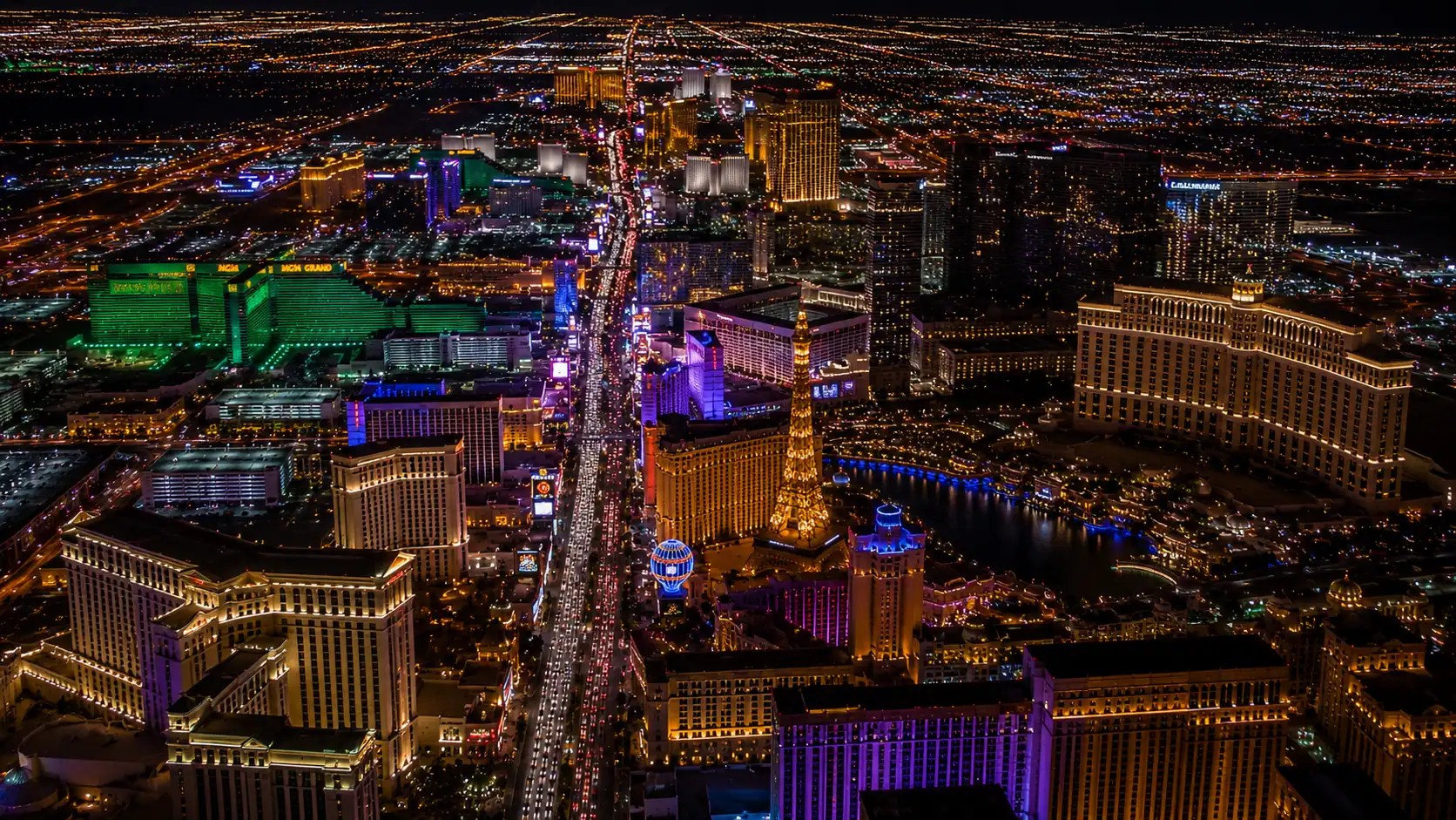 Aerial nighttime view of Las Vegas Strip resort hotel towers all illuminated showing MGM Grand Bellagio Caesars Palace Wynn and Venetian representing Las Vegas hotel inventory statistics