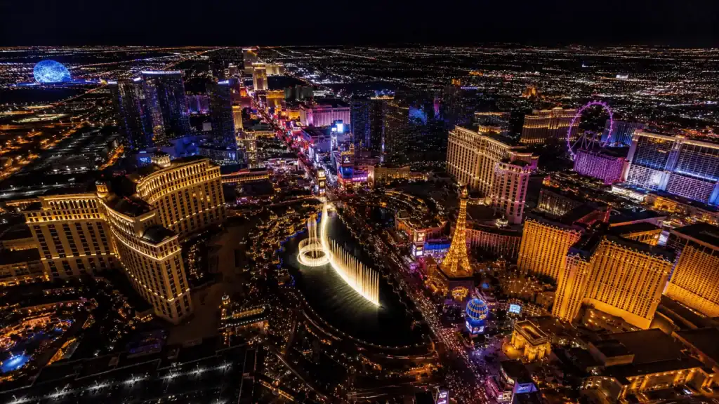 Aerial nighttime view of Paradise Nevada — the unincorporated community that contains the Las Vegas Strip, showing Bellagio fountains and the Sphere lit at night