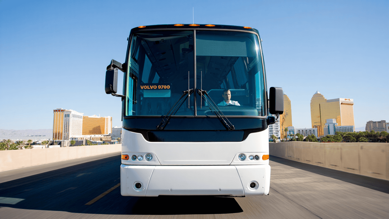 White Volvo 9700 Charter Bus with a suited chauffeur driving through Las Vegas - Personal Sedan Services