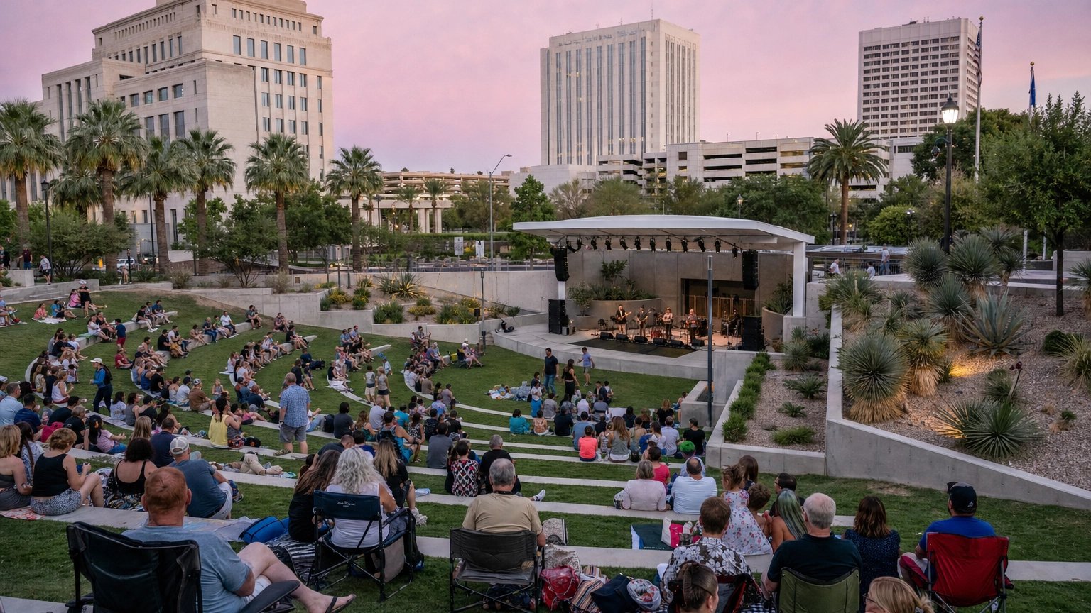 Open-air Las Vegas amphitheater with tiered lawn seating and a stage at dusk during a community concert