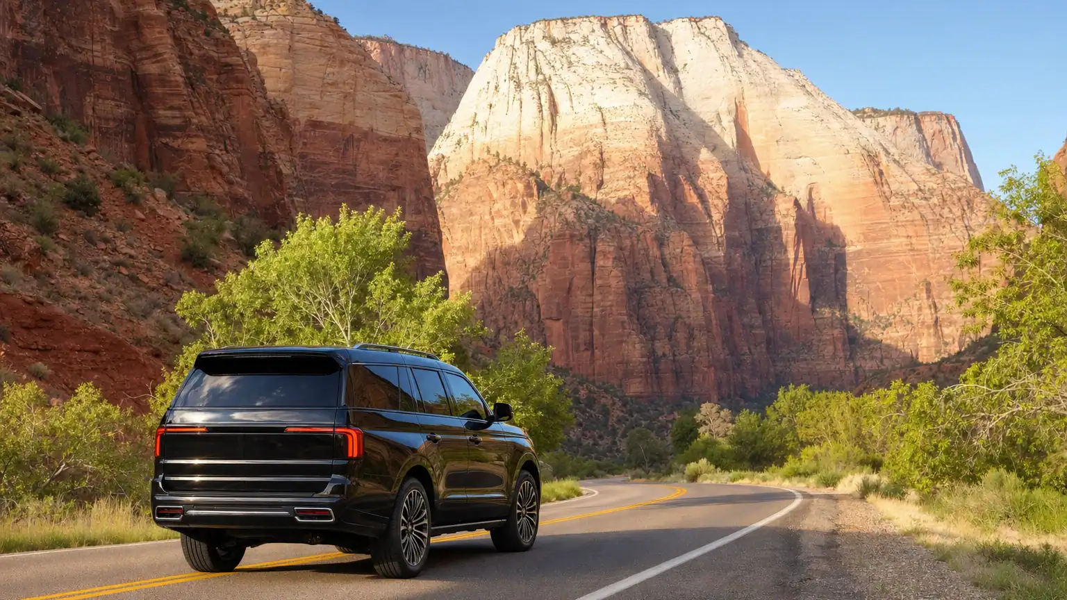 Black luxury SUV on a highway heading toward the red sandstone cliffs of Zion National Park at golden hour