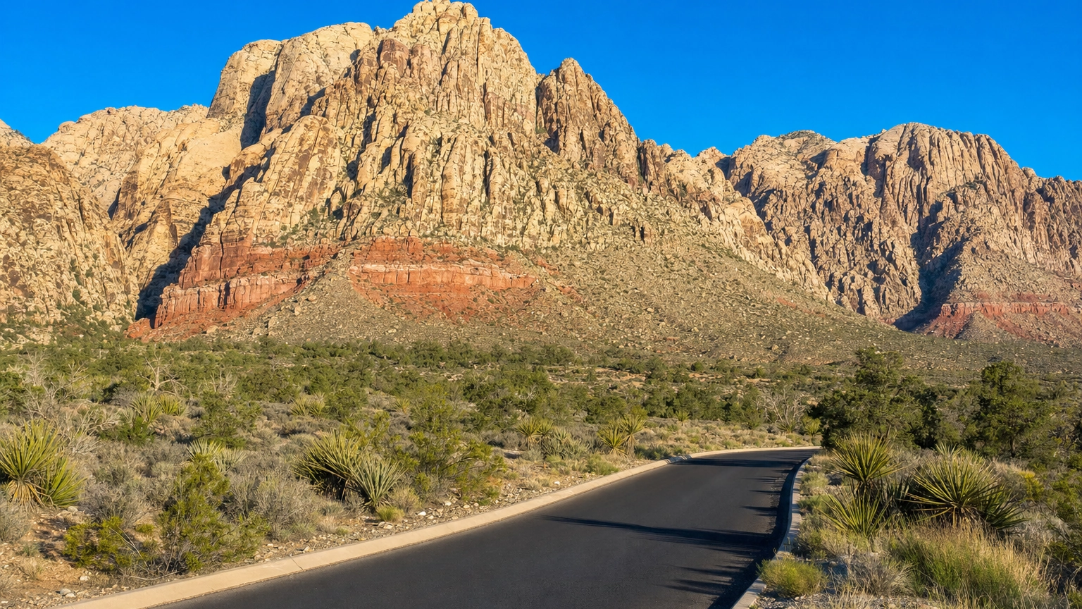 Layered red and cream sandstone cliffs above the Scenic Drive at Red Rock Canyon near Las Vegas in morning light